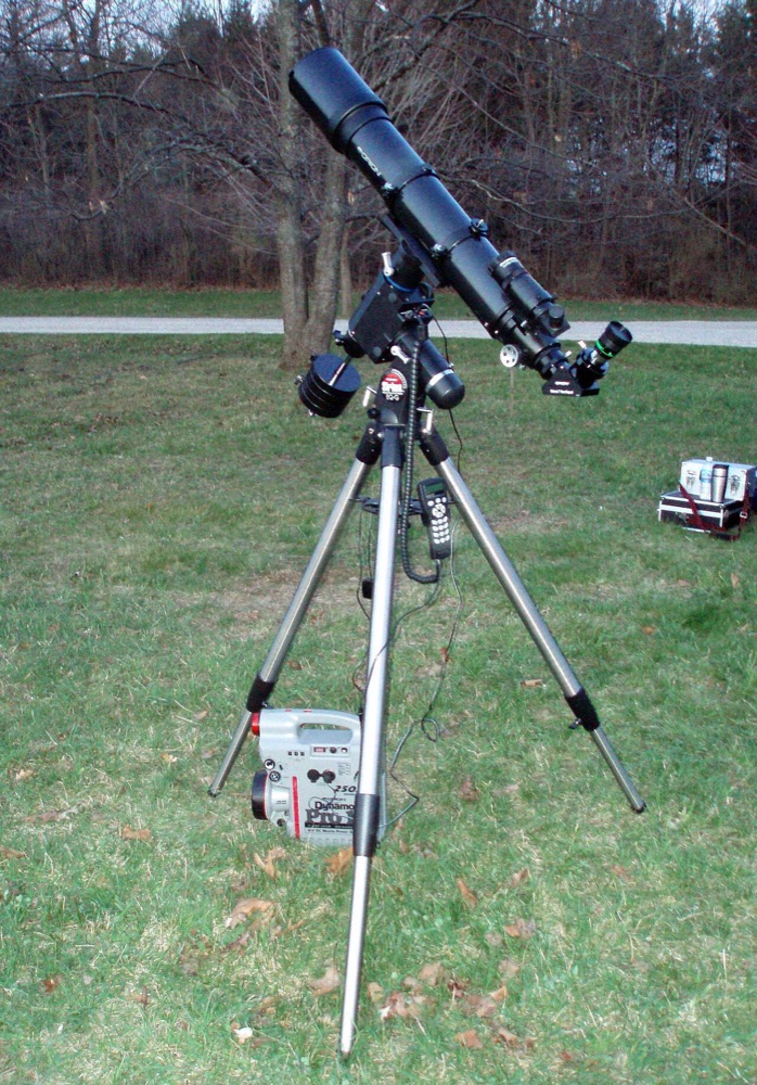 Télescope réfracteur installé sur son trépied dans l'herbe, prêt à être utilisé pour une première soirée d'observation