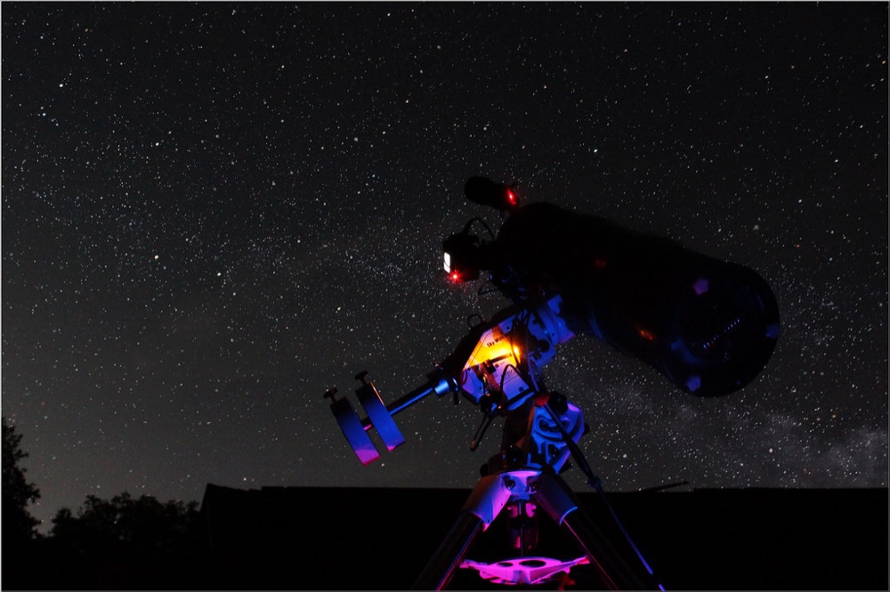 Un instrument d'astronomie sur trépied sous la Voie lactée, comme pour observer avec une lunette astronomique