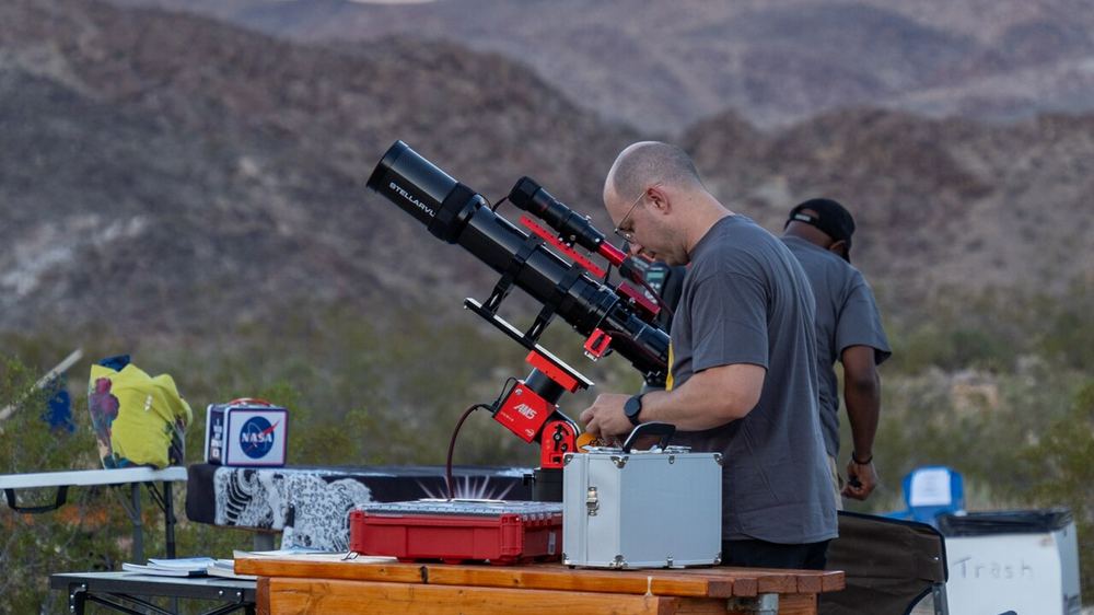 Observateur réglant son instrument au crépuscule pour observer les étoiles avec un télescope
