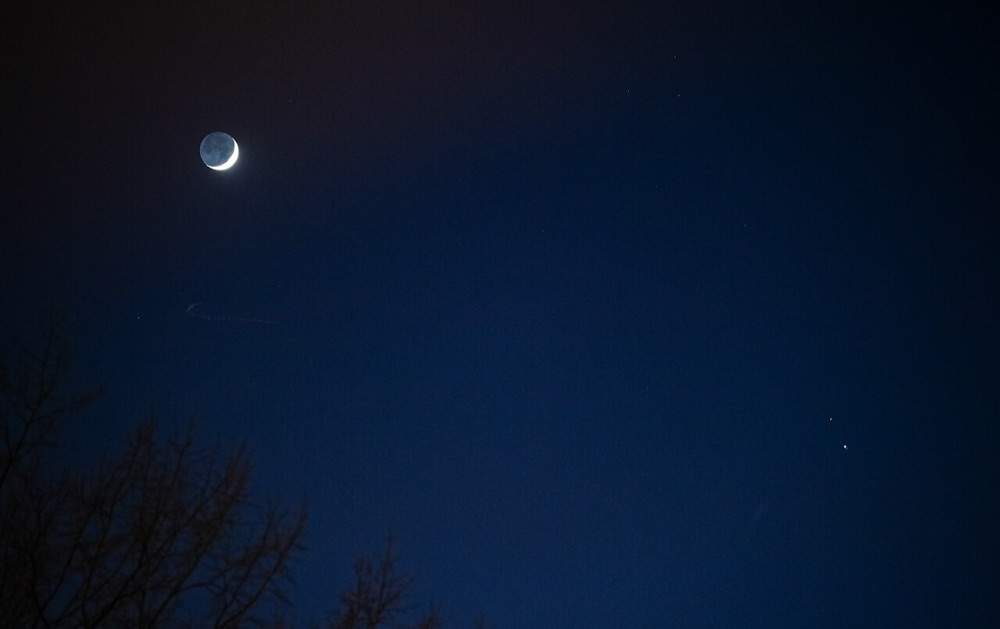 Croissant de Lune dans le ciel du soir, avec deux planètes brillantes visibles à droite, ce que l'on voit avec un télescope de débutant