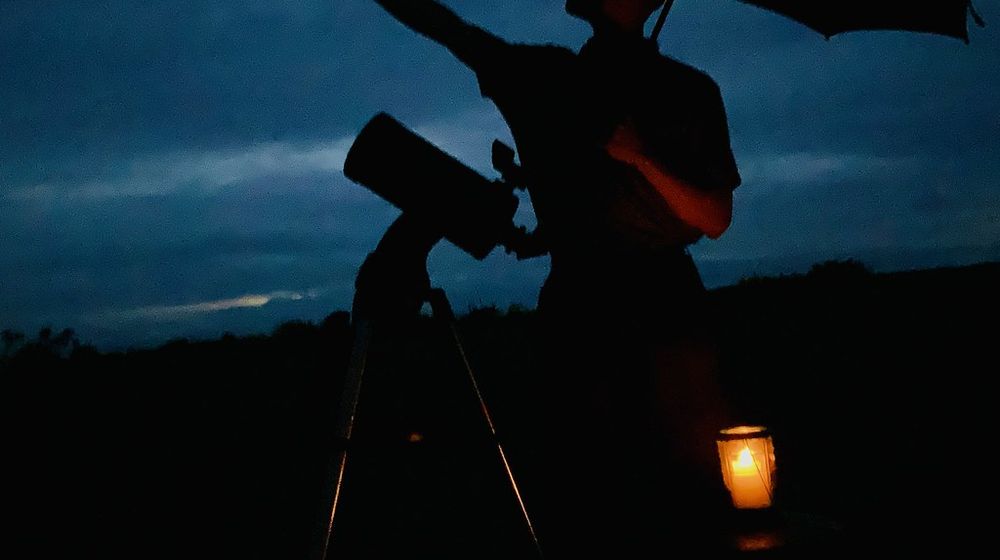 Adulte regardant dans un télescope débutant adulte au crépuscule